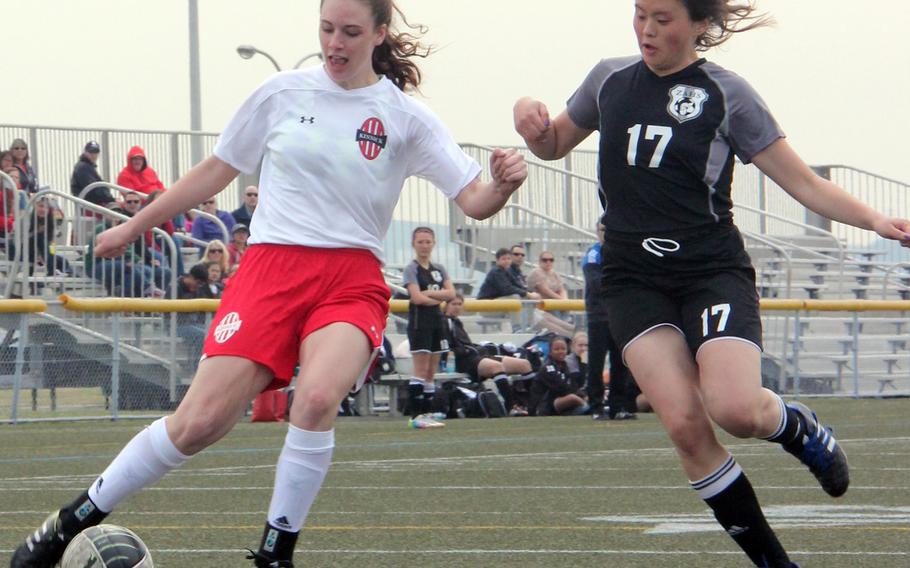 Nile C. Kinnick's Katrina Reid and Zama's Kimi Stuckey pursue the ball during Saturday's Kanto Plain/DODDS Japan girls soccer match. The Red Devils won 3-0, with Reid - a former Trojan playing her first match against her old team - scoring a goal and adding an assist.