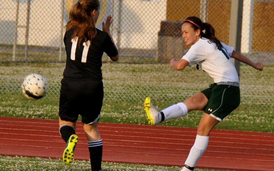 Kubasaki's Ami Eldridge boots the ball past Kadena's Sydne Fletcher during Wednesday's Okinawa high school soccer match. The host Dragons blanked the Panthers 2-0.