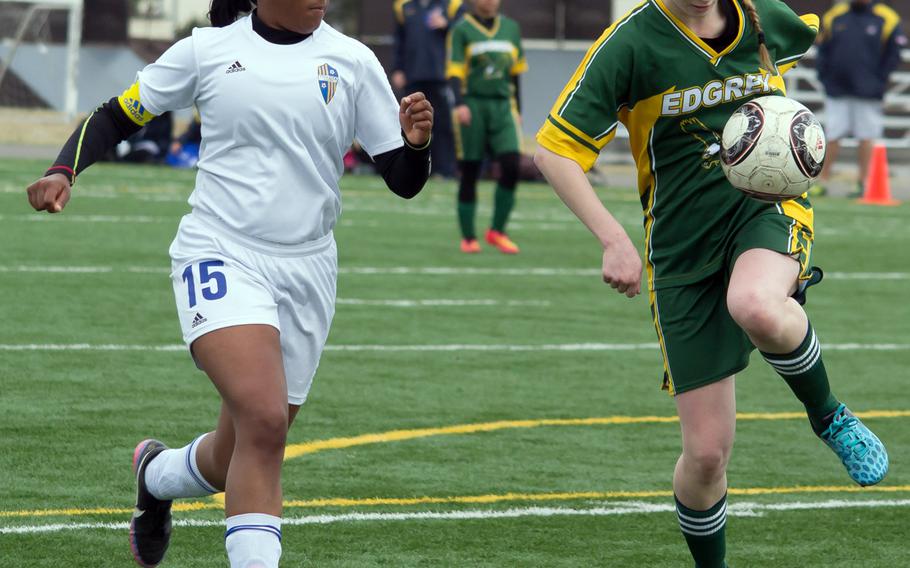 Robert D. Edgren's Nina Robertson plays the ball as Yokota's London Jackson gives chase during Saturday's DODDS Japan girls soccer match. The visiting Panthers edged the Eagles 2-1.