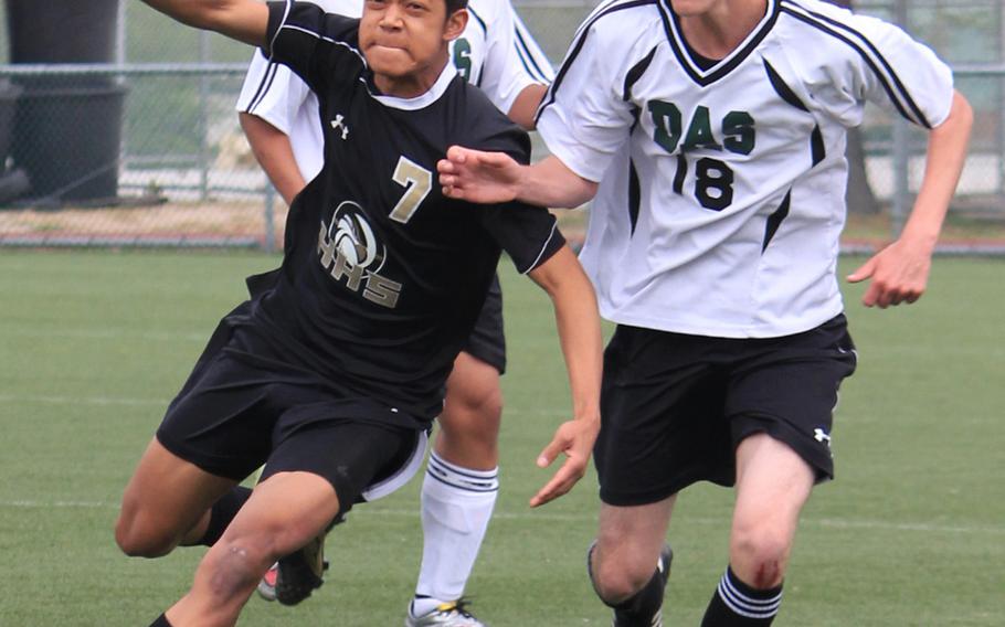 Humphreys' Takao Elliot and Daegu's Dennis Cowins try to play the ball during Saturday's Korea boys soccer match. The visiting Blackhawks edged the Warriors 2-1.