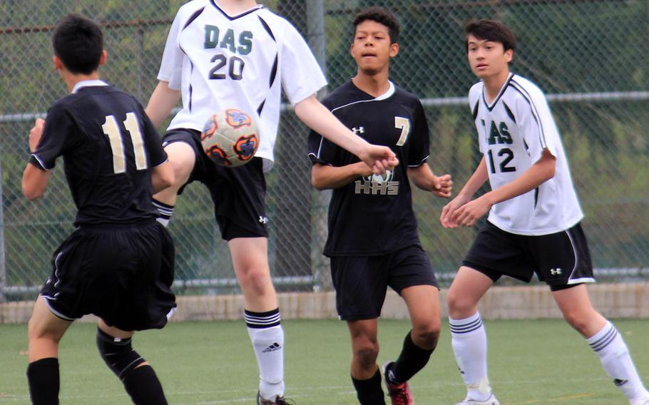 Daegu's Nathan Scheidt plays the ball as Humphreys' Brice Bulotovich and Takao Elliot and Warriors teammate Jonas Langlois watch during Saturday's Korea boys soccer match. The visiting Blackhawks edged the Warriors 2-1.