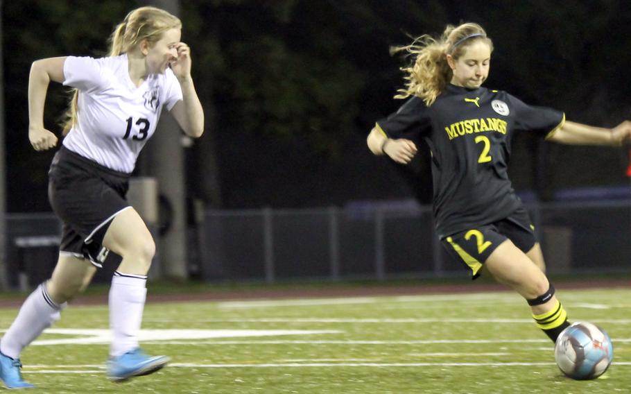 Zama's Madison Ward tries to chase down American School In Japan's Erin Blank playing the ball during Tuesday's Kanto Plain girls soccer match. Blank had two goals and two assists as the visiting Mustangs downed the Trojans 7-1.