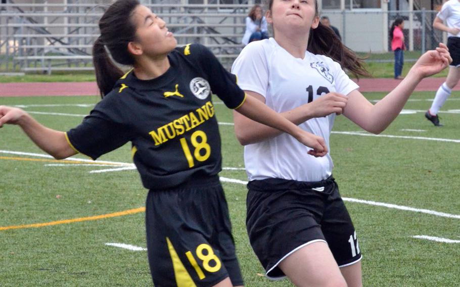 American School In Japan's Mei Kobayashi and Zama's Malina Camacho try to play the ball during Tuesday's Kanto Plain girls soccer match. The visiting Mustangs downed the Trojans 7-1.