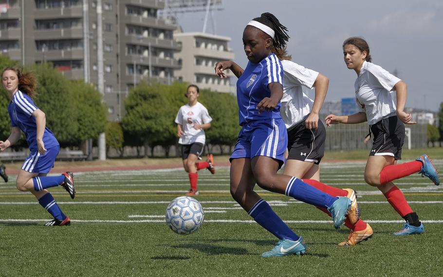 Yokota's Jamia Bailey dribbles past E.J. King defenders April 24, 2015 during group play of the DODDS Japan District girls soccer tournament at Yokota Air Base, Japan. Yokota won 8-0.
