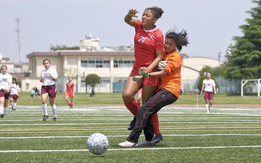 Nile C. Kinnick's Lexia Hall collides with Matthew C. Perry's  Faith Lobaton  April 24, 2015 during the DODDS Japan District girls soccer tournament at Yokota Air Base, Japan. The Red Devils won 10-1.