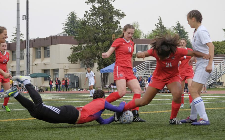 Yokota goalkeeper Sara Cronin dives for the ball as Nile C. Kinnick's Lexia Hall fights for control during the championship match of the DODDS Japan Girls Soccer Tournament at Yokota Air Base, Japan on Saturday, April 25, 2015. Kinnick went on to win the title 3-1.