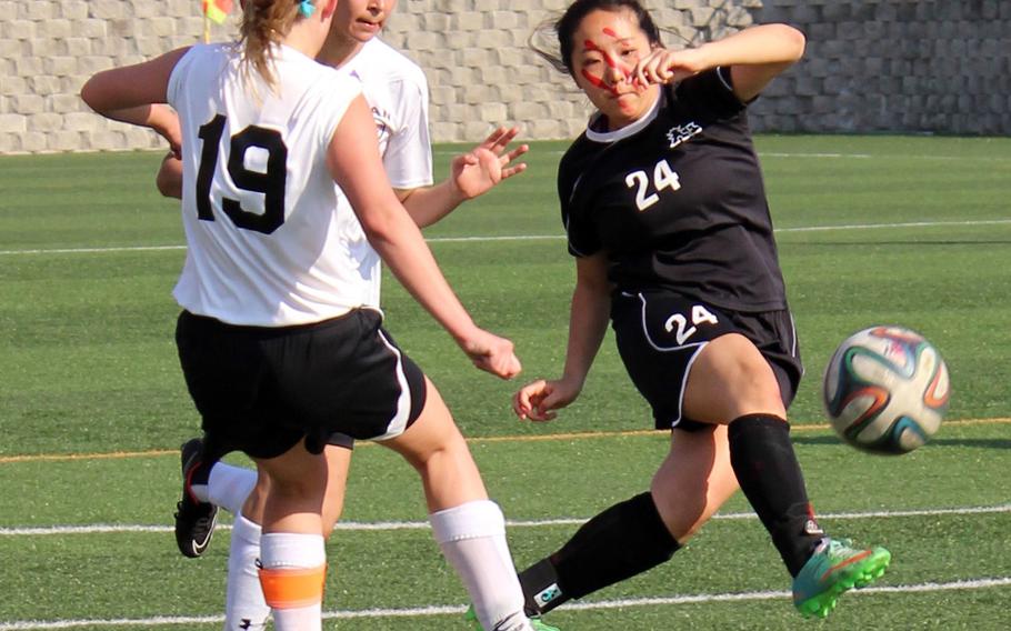 Seoul Foreign's Ji Won Shin boots the ball in front of Osan American's Jennifer Brace and Haeley Deeney during Saturday's Korea girls soccer tournament final on Saturday, April 25, 2015, won by the Crusaders 4-2 over the regular-season champion Cougars.