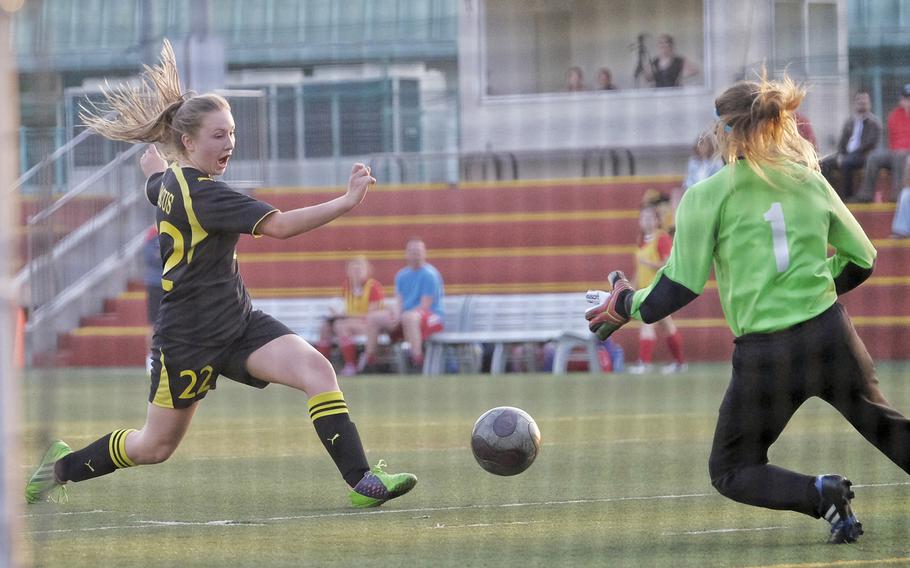 American School in Japan's Nicole Dacus takes a shot on goal while Nile C. Kinnick goalkeeper Alexia Storey defends April 27, 2015, at ASIJ in Chofu, Japan. The match ended in a 1-1 draw.