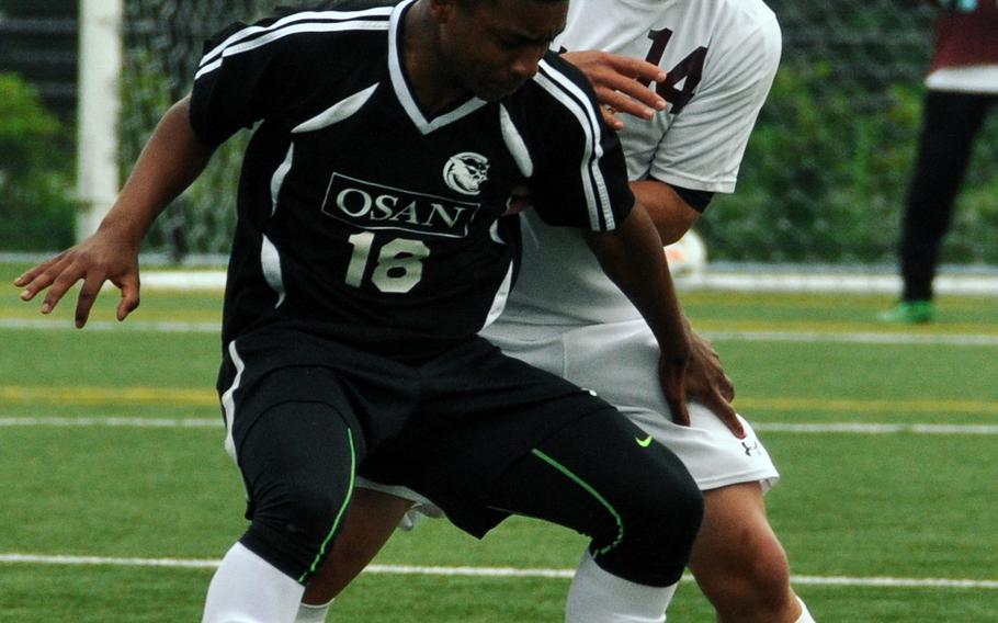 Osan's Nick White and Perry's Masato Poirer play the ball during boys D-II soccer action. The Samurai won 1-0.