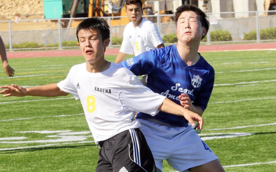 Kadena's Josh Stackpoole and Seoul American's Kevin Hwang make a play for the ball during boys D-I soccer action. The Falcons won 3-1.