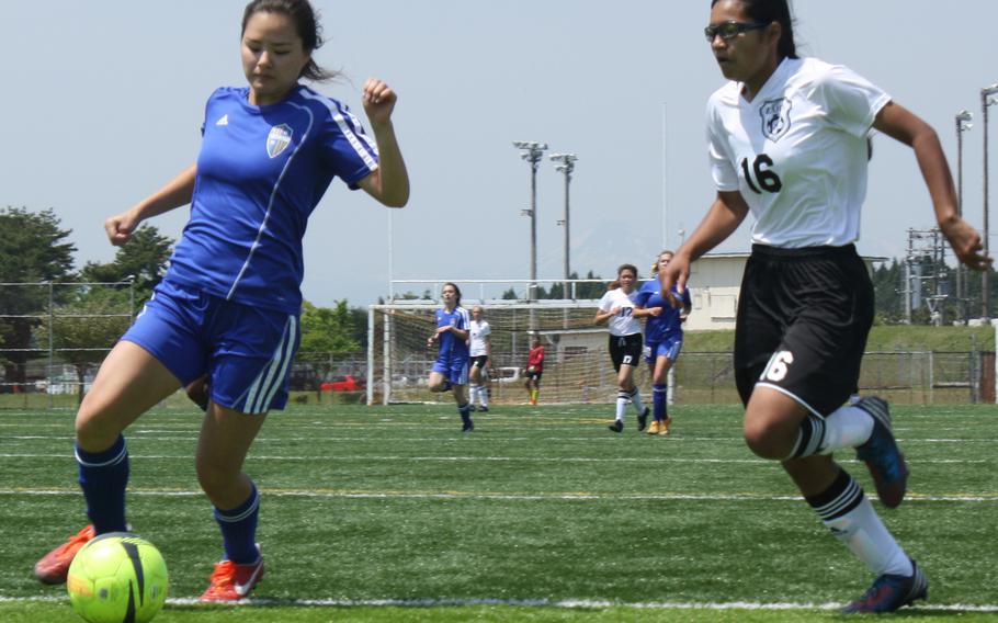 Zama's Rachel Bostick chases Yokota ballhandler Alicia Trask in girls D-II soccer action. The teams tied 1-1.