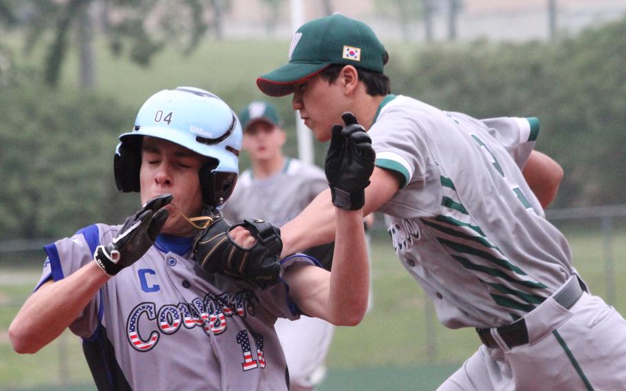 Daegu's Sean White tags Osan's Aaron Misner during the Cougars' 15-2 win in boys D-II baseball action.