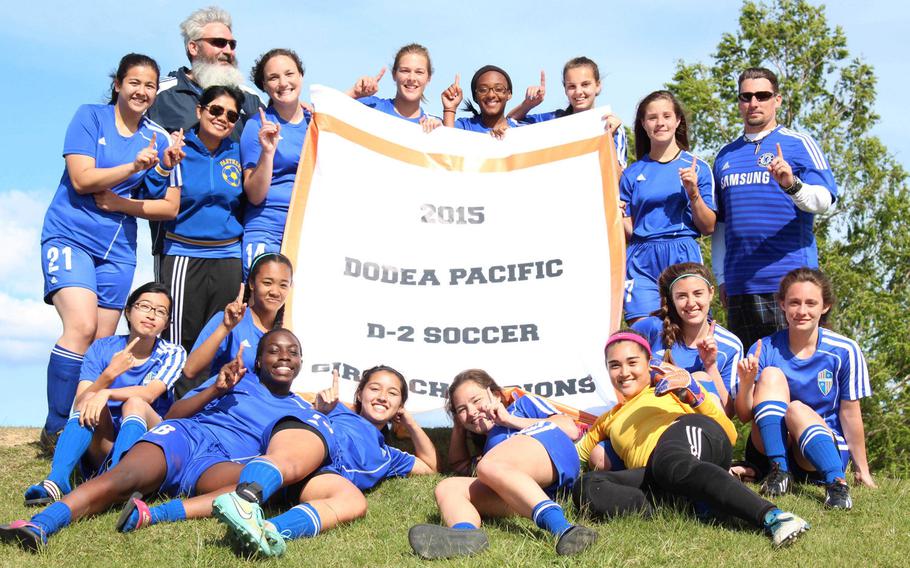 Raising the school's first soccer banner of any type. Yokota players and coaches gather 'round the banner after shutting out Perry 3-0 in the finals of the Far East girls D-II tournament.