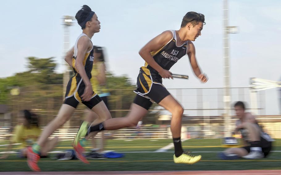American School in Japan's Ken Baburek takes off after receiving the baton from Keiichiro Kinoshita on May 22, 2015 during the 4x400 relay at the Far East Track and Field Tournament at Yokota Air Base, Japan . ASIJ broke the meet record with a time of 3 minutes, 25.45 seconds.