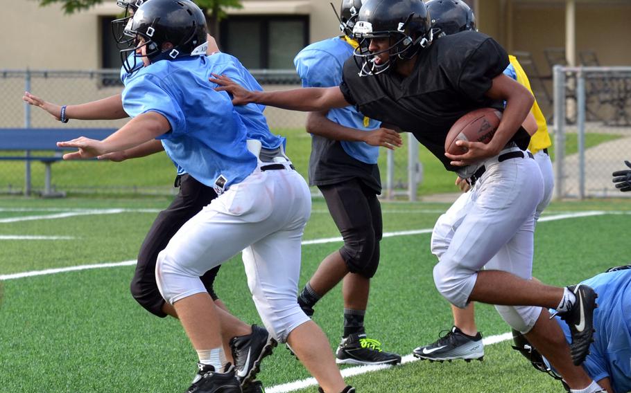Osan running back Chris Moore follows lead blockers during practice.