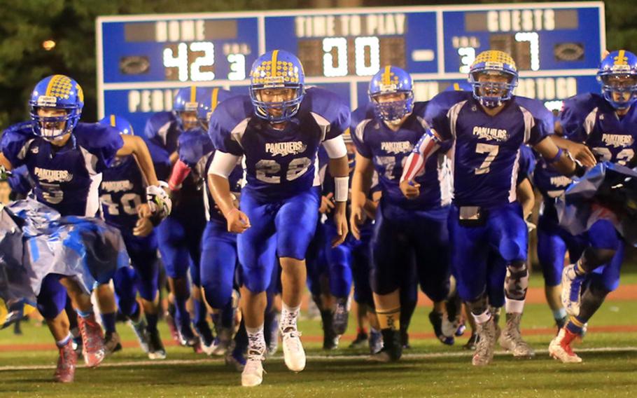 Yokota Panthers backs Shota Sprunger, from left, Jam Harveyand Marcus Henagan lead the team onto the field for the second half. The three combined for 473 yards total offense, Sprunger scoring four times, Harvey twice and Henagan accounting for three touchdowns.