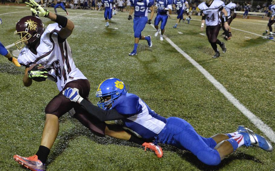 Matthew C. Perry receiver Tyson Moore gets hauled down from behind by Yokota defensive back Robert Johnson.