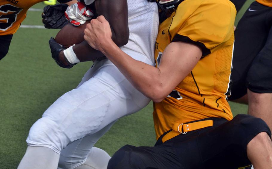 Kubasaki RB Javohn Journigan gets dragged down from behind by American School In Japan's Drew Meany.