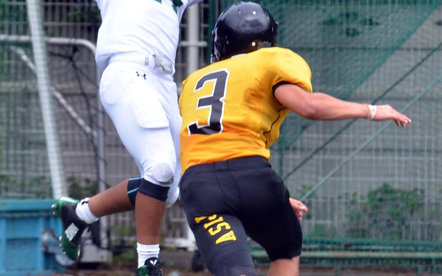 Kubasaki's Lester Parker leaps for a touchdown pass out of reach of American School In Japan defender Henrik Olsson.
