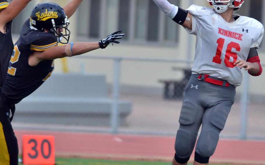 Nile C. Kinnick quarterback Brad Deibel gets rid of the ball amid a Kadena pass rush; Panthers' Abe Patterson intercepted the pass and returned it 34 yards for a fourth-quarter touchdown.