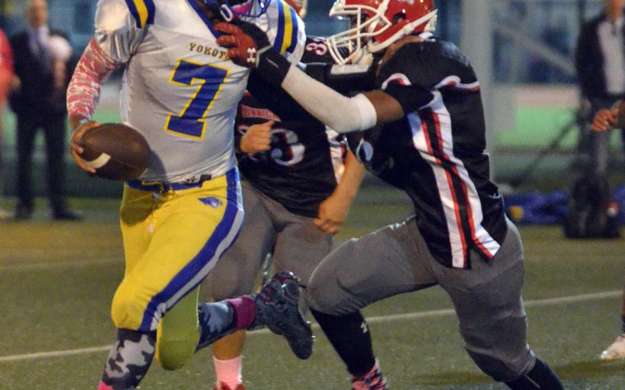 Yokota QB Marcus Henagan tries to elude two Nile C. Kinnick defenders.