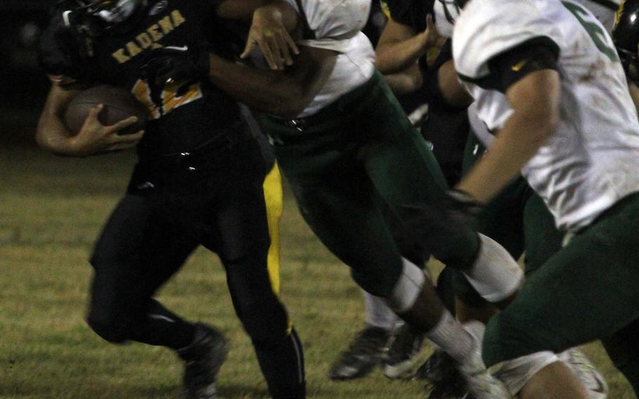 Kadena running back Keith Duenas gets corralled by a host of Kubasaki defenders.