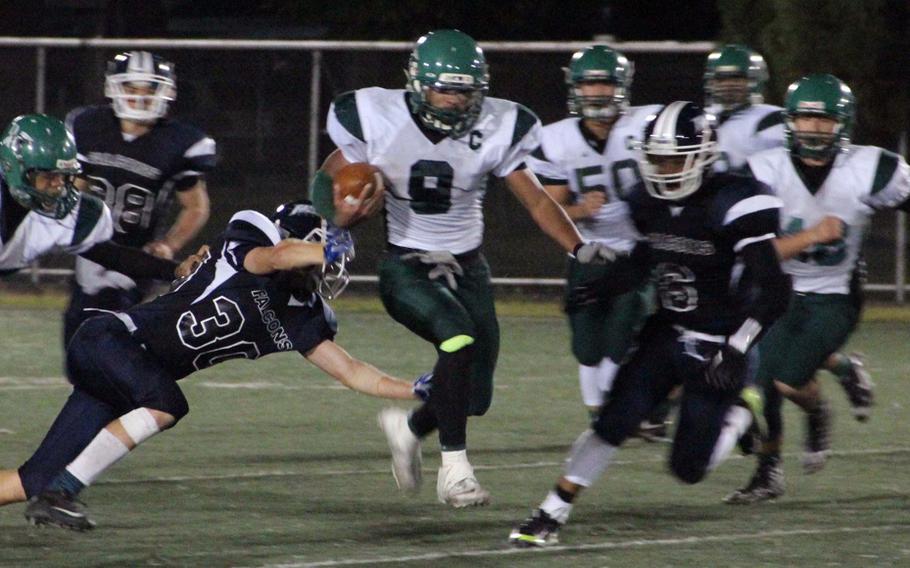 Daegu High QB DeAndre Rosalie eludes the tackle of Seoul American's Eben Shelton and weaves his way through traffic on Oct. 9, 2015.