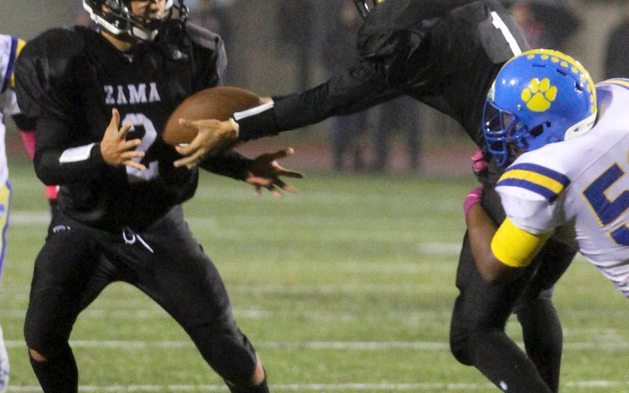 Zama QB K.J. Cruz gets a handoff to RB Keiyl Sasano as Yokota tackler Jalen Harrison closes in Friday at Camp Zama, Japan.