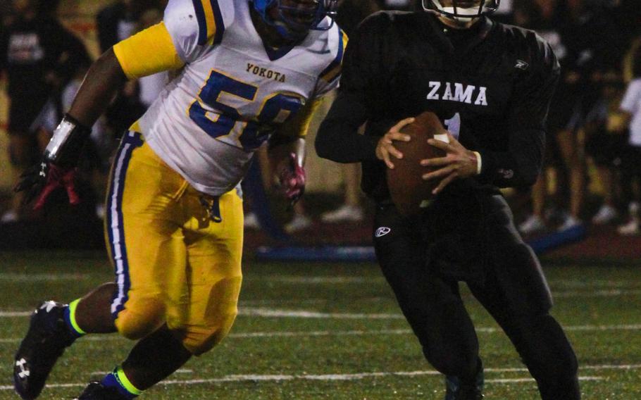 Zama QB K.J. Cruz looks to elude Yokota defender Jalen Harrison on Friday at Camp Zama, Japan.