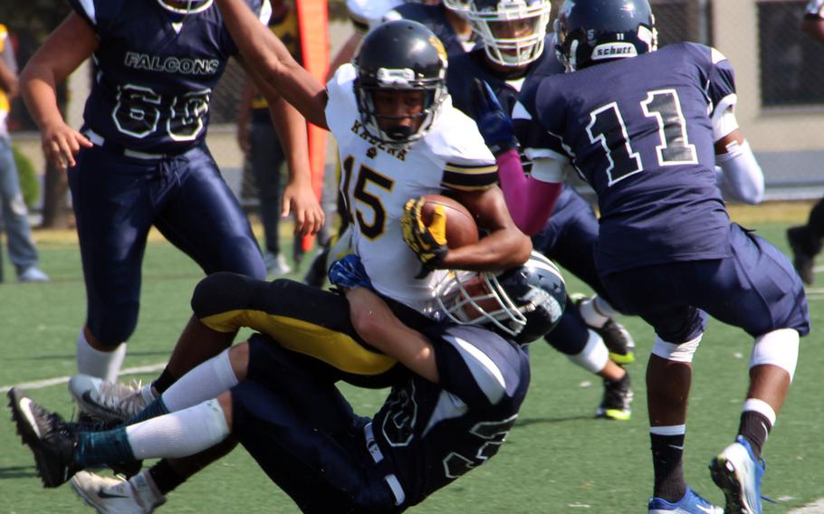 Kadena running back Jason Bland is tackled by Seoul American's Eben Shelton.