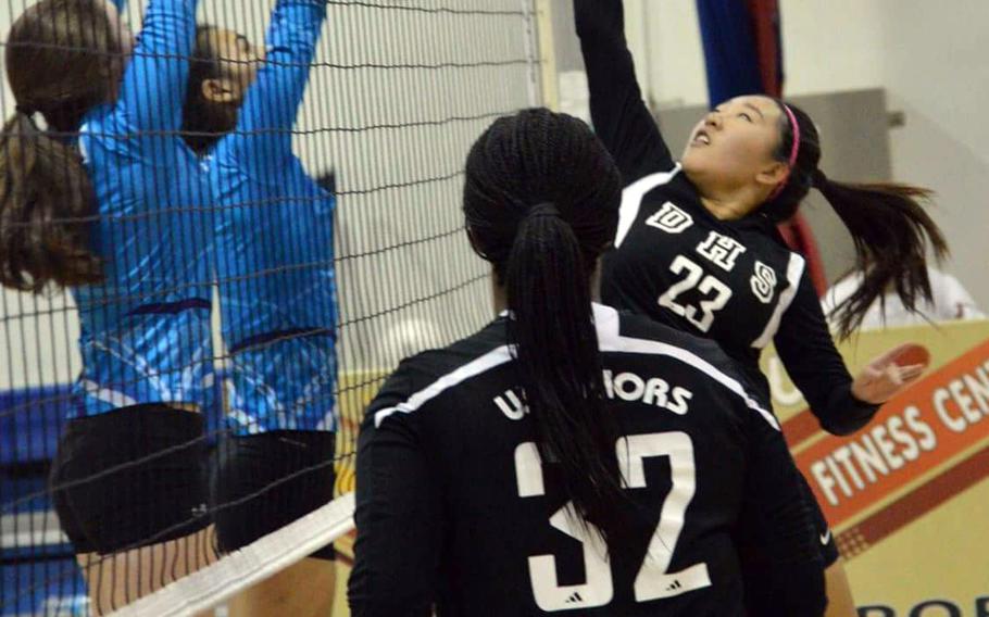 Daegu's Jinna Yu hits the ball against Osan's Hailie Nugent and Jennifer Brace as Warriors teammate Ariyana Canty watches during Friday's Korea Blue Division girls volleyball match. The Cougars won in straight sets.