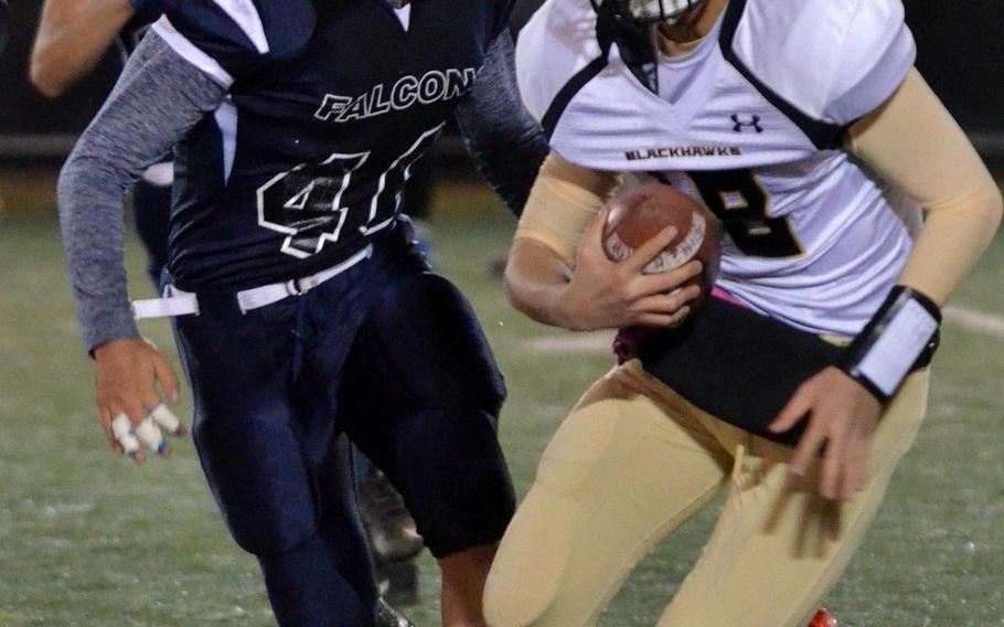 Humphreys QB Brice Bulotovich is sent on the run by Seoul American defender Brandon Rothe.