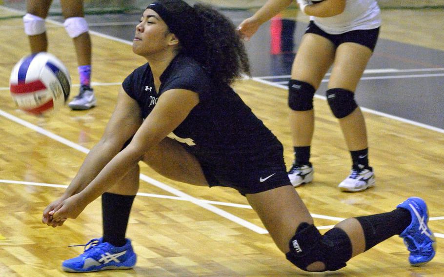 Zama's Loea Richardson leans down to dig a ball during Monday's pool-play match in the Far East High School Division II Girls Volleyball Tournament. The Trojans split their two matches Monday to finish second in Pool B.