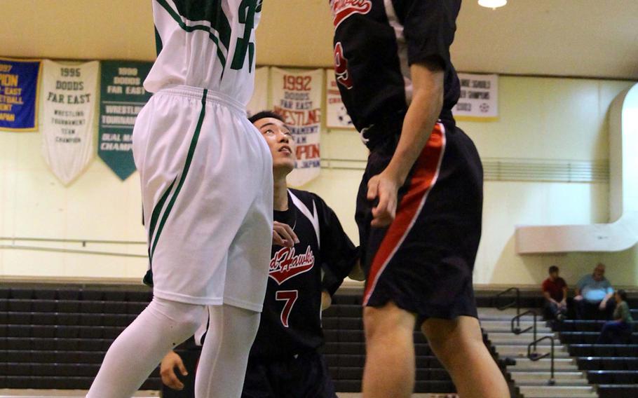 Kubasaki's Matt Ashley goes up for a shot against a Ginowan defender during Tuesday's season-opening game. Ashley led the Dragons with 21 points and Kubasaki beat the Red Hawks 105-82.
