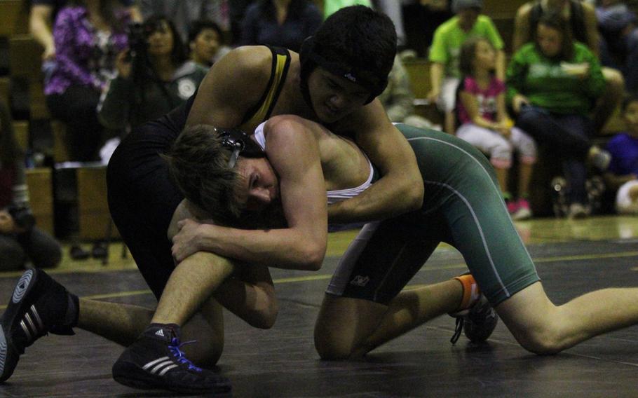 Kadena's Kristian Barela takes control early on Kubasaki's Nick Jenkins in the 129-pound bout of Tuesday's Okinawa district season-opening wrestling dual meet. Jenkins won by decision 15-10, but the Panthers outlasted the Dragons 33-29.