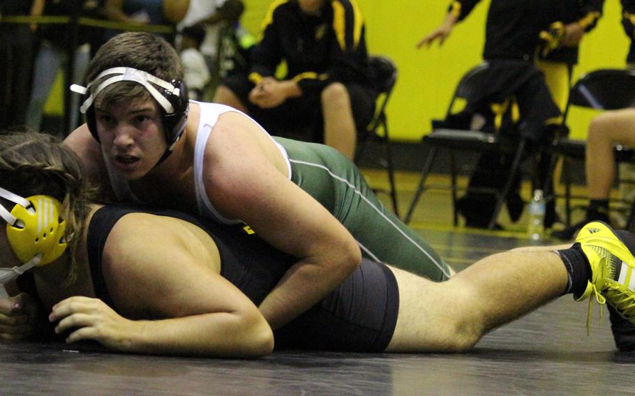 Kubasaki's Tristan Young gains the upper hand on Kadena's Alek Gomez in the 215-pound bout of Tuesday's Okinawa district season-opening wrestling dual meet. Young pinned Gomez in 4 minutes, 55 seconds, but the Panthers outlasted the Dragons 33-29.