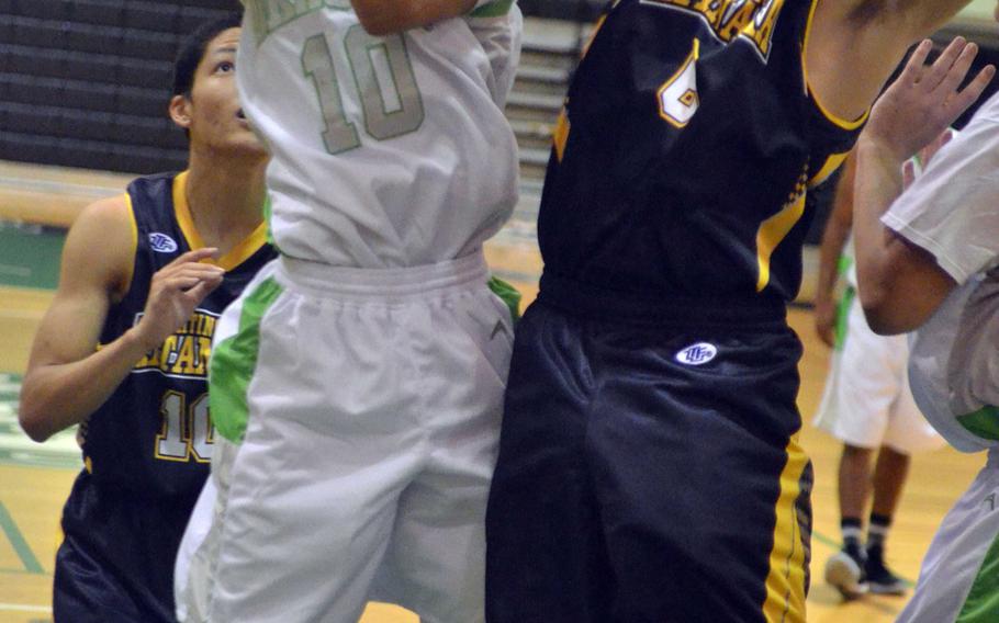 Kubasaki's Imani Washington goes up to shoot against Kitanakagusuku's Kainalu Motes during Wednesday's high school boys basketball game. The Dragons prevailed over the Fighting Lions 108-91.