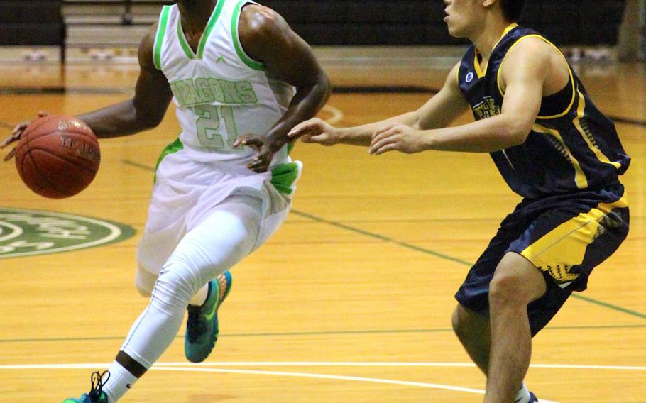 Kubasaki's Isaiah Johnson drives to the basket against Kitanakagusuku's Masazumi Isa during Wednesday's high school boys basketball game. The Dragons outlasted the Fighting Lions 108-91.