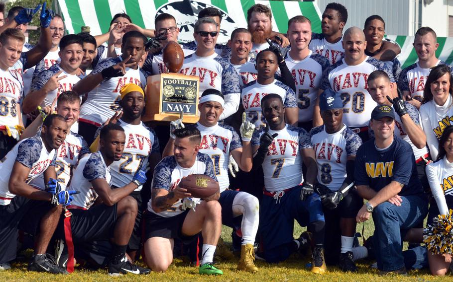 Navy players, coaches and command staff gather round the championship trophy following their 29-6 flag-football rivalry win over Army at Torii Station, Okinawa.