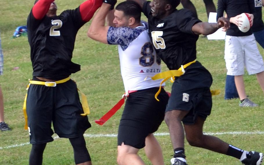 Navy's Gregg Nieten gets sandwiched going up for the football between Army's Josh Mitchell and Bradley Burke during a flag-football game Saturday at Torii Station, Okinawa.