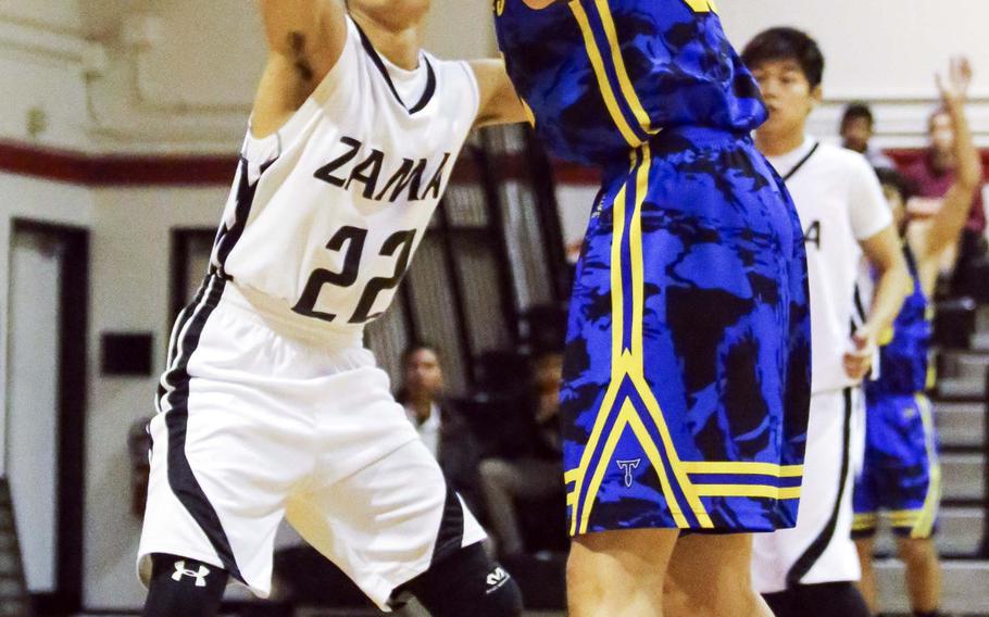 Zama's Shinya Hamada defends against St. Mary's Josh Byland during Tuesday's boys basketball game, won by the Titans 49-28.