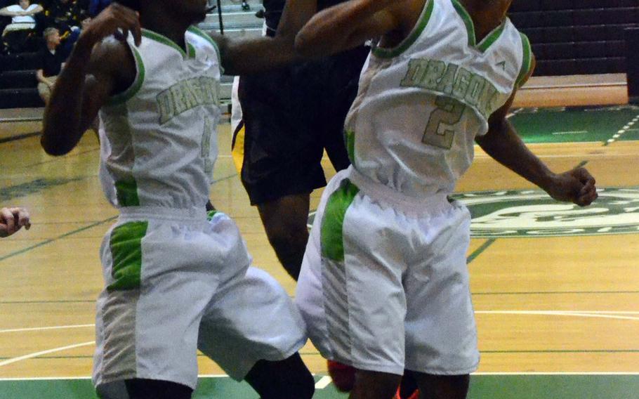 Kadena's Jeremiah Steed shoots over Kubasaki's Xavier Carmouche and Jacob Green during Wednesday's boys basketball game, won by the Dragons 56-36.