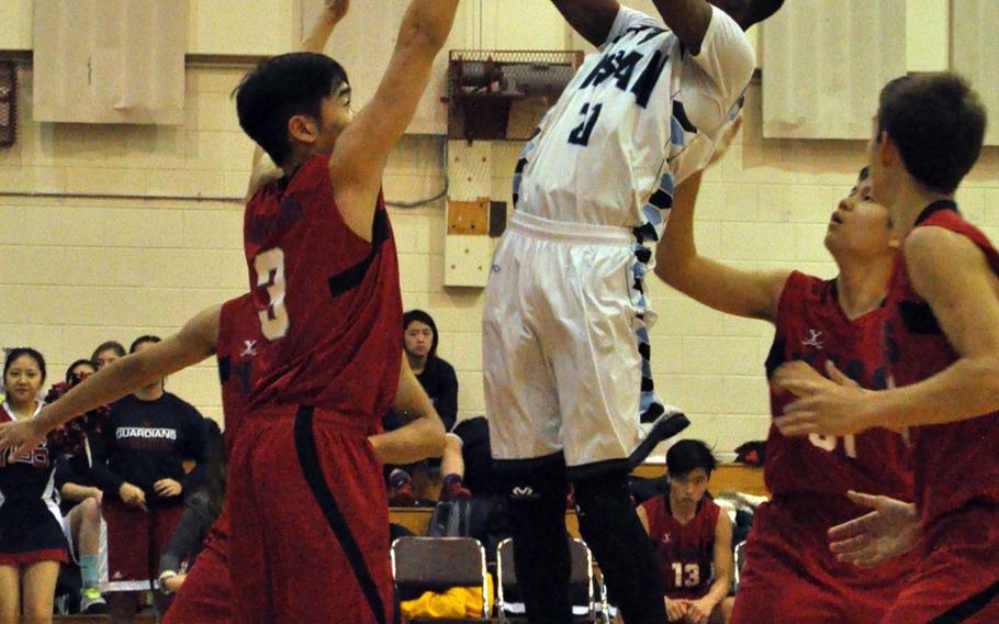 Osan's Darius Dawson shoots over Yongsan's Taeho Kim during Friday's boys basketball game, won by the Cougars 44-40.