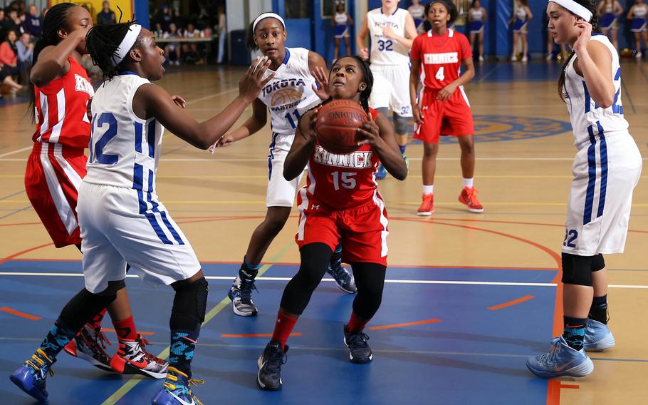Nile C. Kinnick's Dazlyn Brown looks to shoot between Yokota defenders Jamia Bailey, Kaliah Henderson and Sarah Cronin during Wednesday's high school girls basketball game, won by the Panthers 70-41.