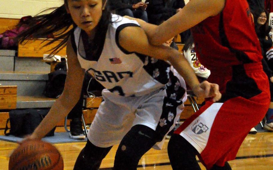 Osan's Andrea Carandang dribbles against Seoul Foreign's Sarah Ha during Saturday's girls basketball game, won by the league-leading Crusaders 40-29.