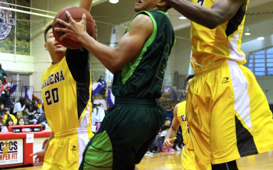 Kubasaki's Jacob Green drives to the basket between Kadena's Donte Savoy and Isaiah Richardsonl during the boys championship game in the 10th Okinawa-American Frienship Basketball Tournament on Sunday, Jan. 24, 2016. The Dragons routed the Panthers 66-46, avenging last year's last-second 63-61 defeat and winning their 27th straight game dating back to that loss.