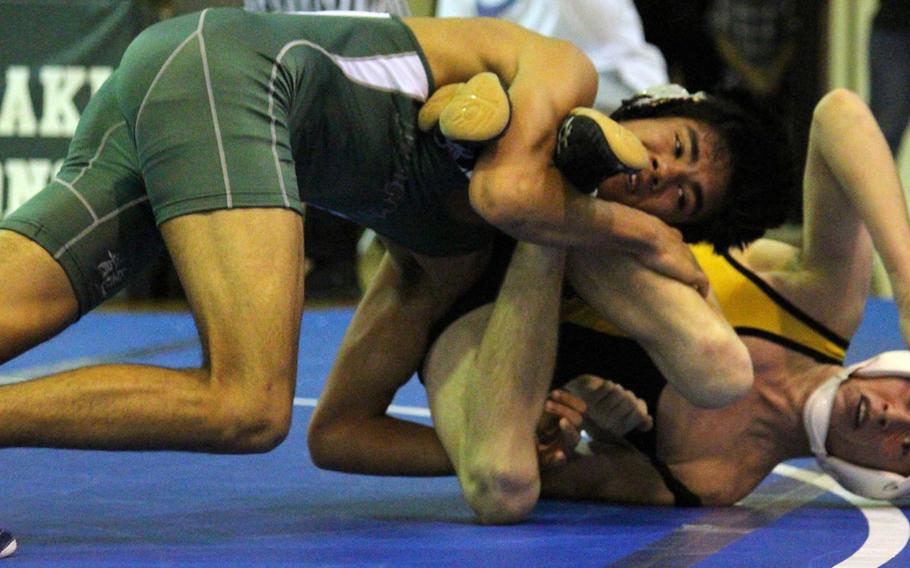 Kubasaki's Josh Figueredo locks in a leg lace on Kadena's Dan Frazier in the 129-pound bout during Wednesday's regular season-ending dual meet. Figueredo won by technical fall 15-2 in 3 minutes, 15 seconds, but the Panthers rallied from 28-6 down to edge the Dragons 33-29 to win the meet.