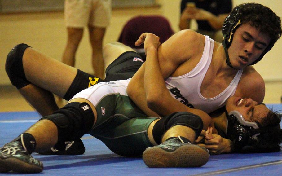 Kubasaki's Kristian Palmer locks in a head-and-arm on Kadena's Adam Trujillo in the 122-pound bout during Wednesday's regular season-ending dual meet. Palmer pinned Trujillo in 4 minutes, 9 seconds, but the Panthers rallied from 28-6 down to edge the Dragons 33-29 to win the meet.