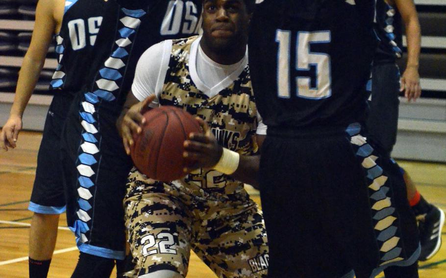 Humphreys' Jaylin Barmer squeezes between a gaggle of Osan defenders during Friday's Korea Blue Division tournament semifinal, won by the Blackhawks 57-29. They face Seoul American in Saturday's final.