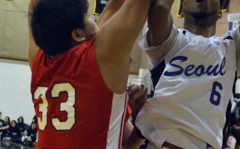 Seoul American's Donnavan Scott runs into Seoul Foreign defender Zander Sohn during Friday's Korea Blue Division tournament semifinals, won by the Falcons 62-48. They face Humphreys in Saturday's final.